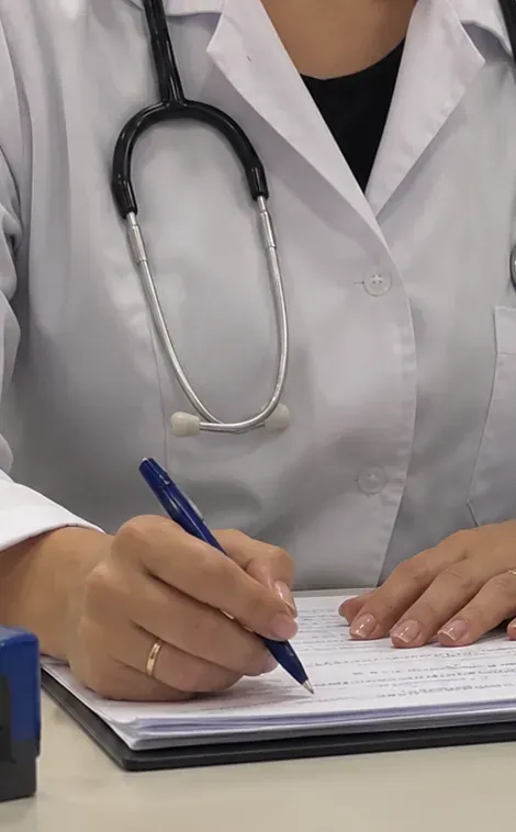 Médecin en blouse blanche écrivant sur une ordonnance lors d'une consultation