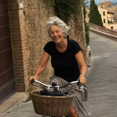 Femme souriante à vélo dans une rue en pente